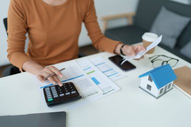 Hesaplama ve Düşünce yapmak için hesap makinesi kullanan Akıllı İpotek Planlayan kadın.