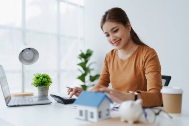 Hesaplama ve Düşünce yapmak için hesap makinesi kullanan Akıllı İpotek Planlayan kadın.