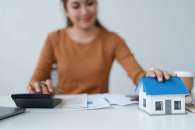 Hesaplama ve Düşünce yapmak için hesap makinesi kullanan Akıllı İpotek Planlayan kadın.