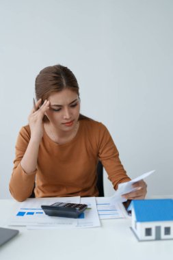 Hesaplama ve Düşünce yapmak için hesap makinesi kullanan Akıllı İpotek Planlayan kadın.
