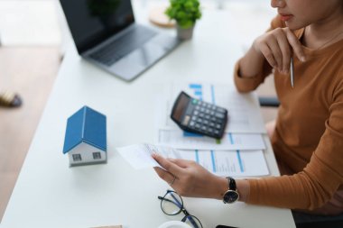 Hesaplama ve Düşünce yapmak için hesap makinesi kullanan Akıllı İpotek Planlayan kadın.