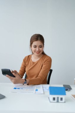 Hesaplama ve Düşünce yapmak için hesap makinesi kullanan Akıllı İpotek Planlayan kadın.