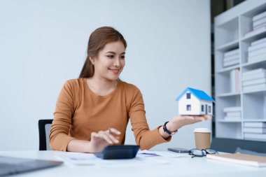 Hesap makinesi, bilgisayar ve belge kullanan Kadın Ev Finansmanı Yönetimi Hesaplama için ipotek.