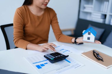 Hesap makinesi, bilgisayar ve belge kullanan Kadın Ev Finansmanı Yönetimi Hesaplama için ipotek.