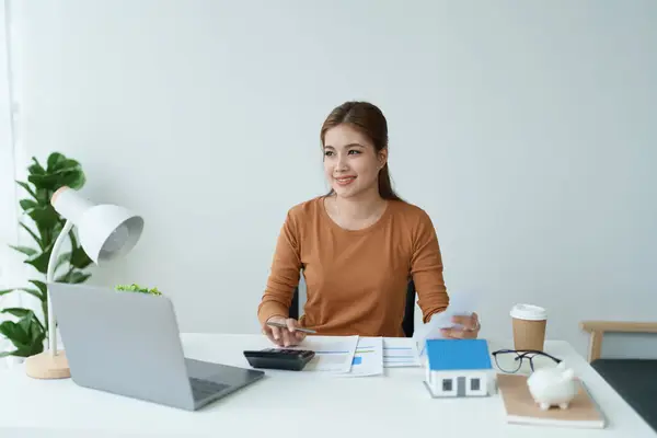 stock image Smart Mortgage Planning woman using a calculator to make Calculations and Consideration.