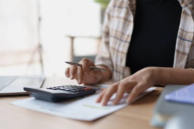 Hesap makinesi, bilgisayar ve belge kullanan Kadın Ev Finansmanı Yönetimi Hesaplama için ipotek.