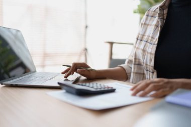 Hesap makinesi, bilgisayar ve belge kullanan Kadın Ev Finansmanı Yönetimi Hesaplama için ipotek.