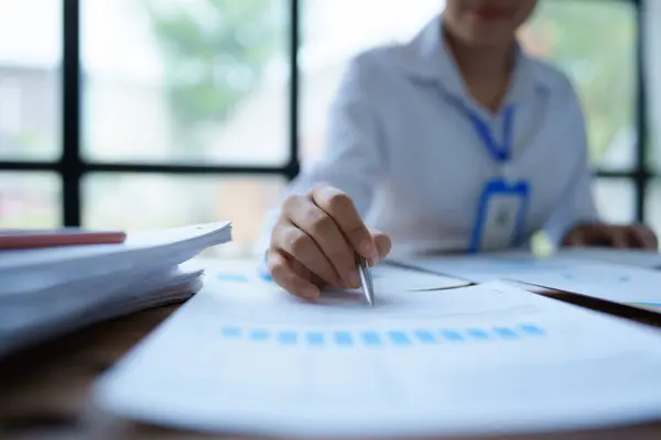 Kadın, ofis mali belgelerini düzenleyerek mali ve bütçe denetimi planlıyor.