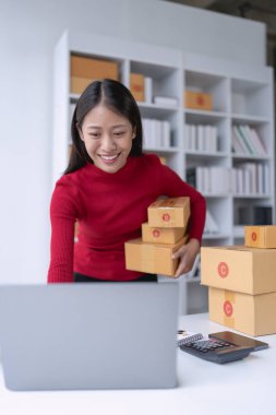 Kadın, çevrimiçi satıcı, tablet bilgisayar kullanarak e-ticaret platformu üzerinden müşteri siparişlerini ve teslimatlarını etkili bir şekilde yönetir..