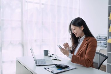 İş kadını, finans için bir pazarlama stratejisi planlamak için akıllı telefon aramasını kullanıyor. Finansal hedefleri pazar olanaklarıyla aynı seviyeye getirmeyi amaçlıyor..