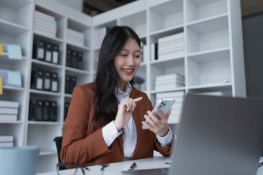 İş kadını, finans için bir pazarlama stratejisi planlamak için akıllı telefon aramasını kullanıyor. Finansal hedefleri pazar olanaklarıyla aynı seviyeye getirmeyi amaçlıyor..