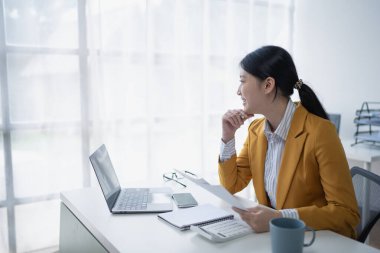 Kadın, ofis mali belgelerini düzenleyerek mali ve bütçe denetimi planlıyor.