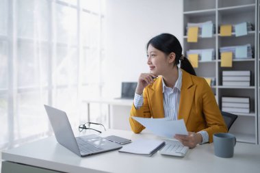 Kadın, ofis mali belgelerini düzenleyerek mali ve bütçe denetimi planlıyor.