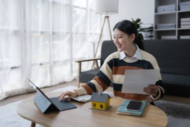 Hesaplama ve Düşünce yapmak için hesap makinesi kullanan Akıllı İpotek Planlayan kadın.