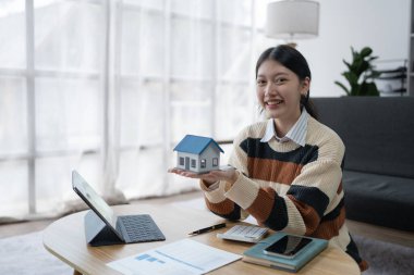 Hesap makinesi, bilgisayar ve belge kullanan Kadın Ev Finansmanı Yönetimi Hesaplama için ipotek.
