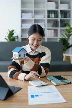 Kadın, konut kredisini güvence altına almaya, ev sahipliği ve uzun vadeli mali istikrar elde etmek için bütçesini dikkatle yönetmeye odaklanmış bir mali tasarruf planı hazırlıyor..