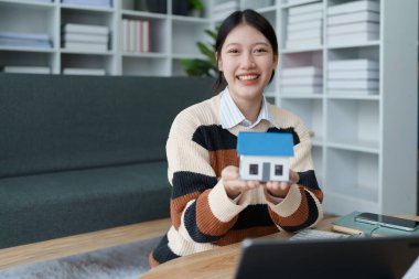 Kadın, konut kredisini güvence altına almaya, ev sahipliği ve uzun vadeli mali istikrar elde etmek için bütçesini dikkatle yönetmeye odaklanmış bir mali tasarruf planı hazırlıyor..
