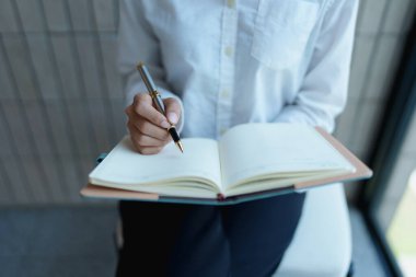 Modern ofis ortamında kalemle bireysel yazılar, yaratıcı ve üretken çalışmalara odaklanmış.