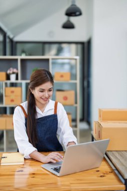 Heyecanlı genç bayan bu ayın ürünlerini satarak elde edilen veri dağıtım ürünlerini görmek için bilgisayar dizüstünü kullanırken başarıyı kutluyor.