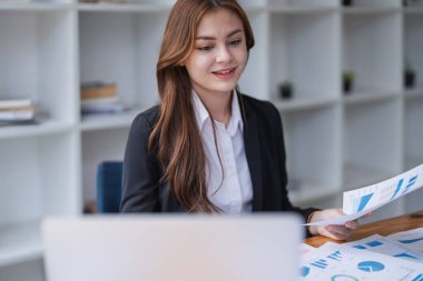 İşyerinde bilgisayarını kullanarak finansal verileri analiz ediyor...