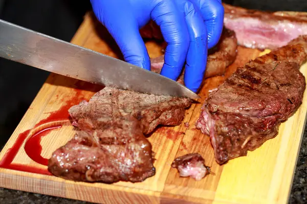 Cutting medium rare beef with a knife.