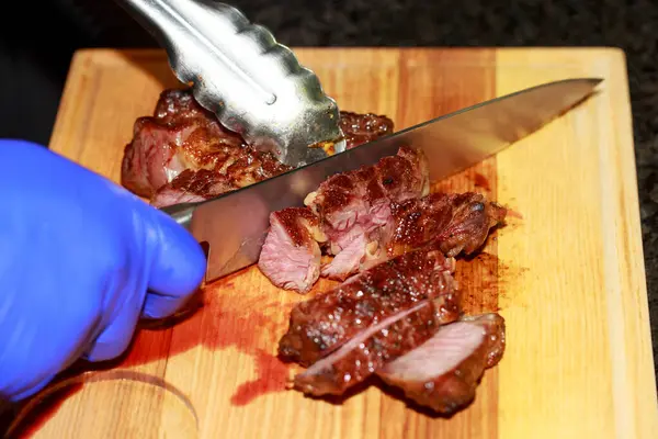 Cutting medium rare beef with a knife.