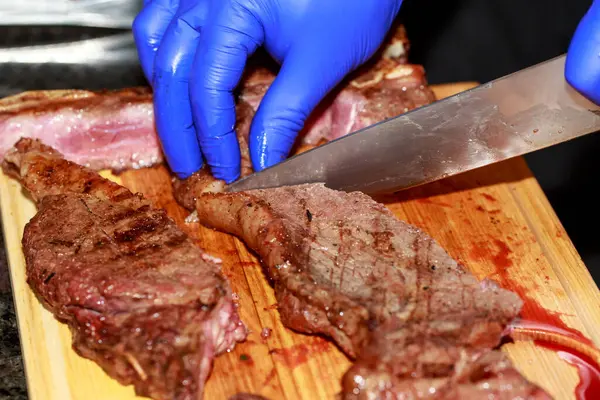 Cutting medium rare beef with a knife.