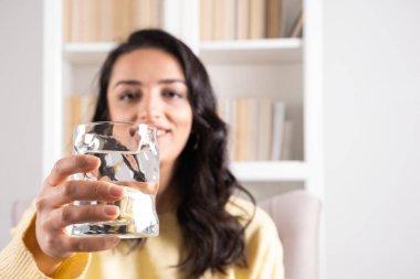 Holding glass of water, close up selective focus on woman holding glass of water. Showing and recommending pure mineral water, copy space. Healthy lifestyle health care concept idea. Refreshment habit