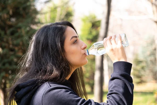 Woman drinking water, side view portrait of caucasian woman drinking water. Enjoying pure fresh mineral crystal still aqua. Thirsty girl after outdoor walking or jogging. Copy space.