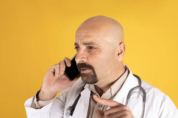 Medicine professional talking on phone, close up side view image of medicine professional talking on phone. Doctor talking over his mobile phone. Thinking and answering patients questions.