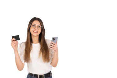 Çevrimiçi ödeme konsepti, mutlu ve heyecanlı genç kız online ödeme konsepti. Elinde siyah plastik kredi kartı ve modern cep telefonu olan esmer bir kadın. İzole edilmiş beyaz kopya alanı