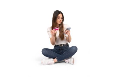 Çevrimiçi bankacılık, beyaz kız kredi kartı tutuyor ve online bankacılık için akıllı telefon kullanıyor. İzole edilmiş beyaz arkaplan, kopyalama alanı. İnternetten alışveriş yapmak, yemek sipariş etmek. Hediye almak için interneti kullanmak..