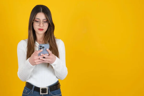 Serious woman using smartphone, portrait of young caucasian serious woman using smartphone. Confident expression smart face, thinking messaging on mobile cell phone. Businesswoman standing, copy space