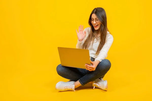 Online meeting, happy caucasian positive young woman attending online meeting. Say hello, greeting. Waving hand. Using laptop for virtual conference, video call, communication with friends, colleagues