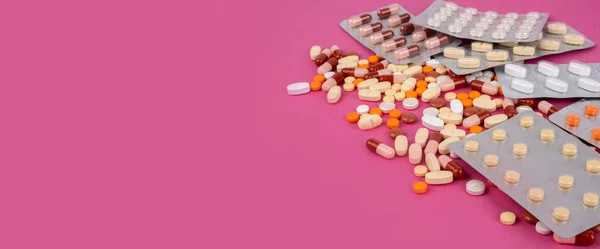 医療用薬のグループ 医療用薬のグループと薬局の概念の背景 カラフルな錠剤 カプセル 未使用のブリスターパック薬をこぼした コピースペースとピンクのバナーのアイデア — ストック写真