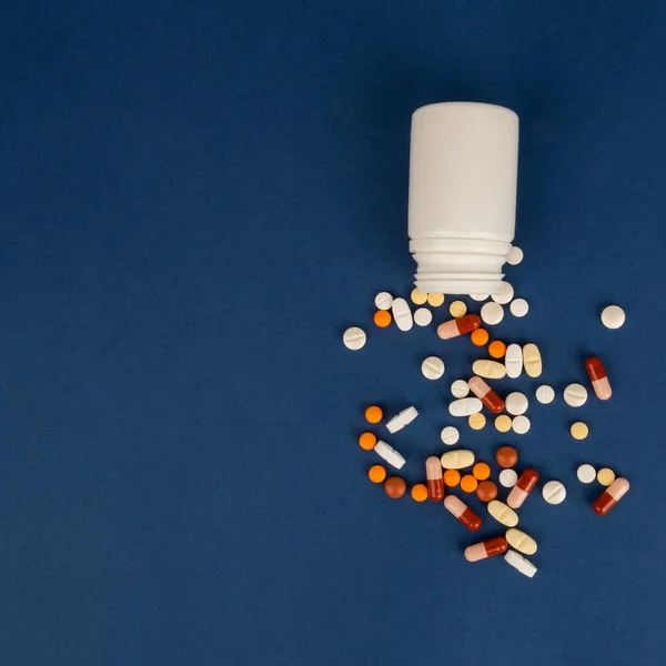 各種医薬品薬のトップビュー画像 錠剤カプセル薬が白いペットボトルをこぼした 隔離された海軍の青の背景 テキストのスペースをコピーします 薬局のテーマ — ストック写真