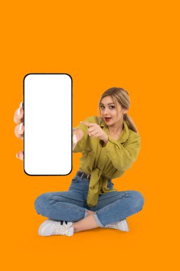 İşaret parmağı cep telefonu modeli, vücut manzaralı genç sarışın kız zemin nokta işaret parmağı cep telefonu modeli. Akıllı telefon gösteriliyor. Önerilen uygulama, afiş.