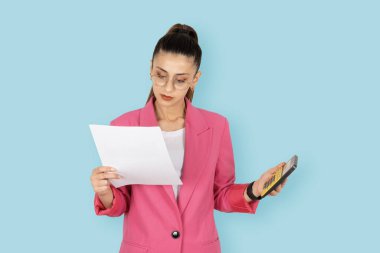 Hesap makinesi kullanan kağıt fatura tutan genç iş kadını hesap makinesi kullanan kağıt fatura tutuyor. Esmer ofis çalışanı muhasebecinin portresi. Finans hesapları, bütçe vergisi ödemeleri.