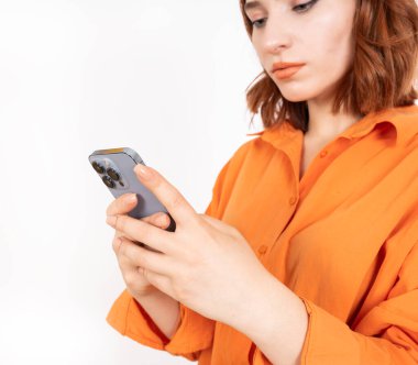 Akıllı telefon kullanarak, akıllı telefon kullanan beyaz saçlı çekici bir kadının kırpılmış görüntüsünü kapatıyoruz. Ciddi düşünceli kadın telefonu tutuyor, ekrana bakıyor, internette sohbet ediyor, uygulamaları tarıyor, video görüşmesi yapıyor..