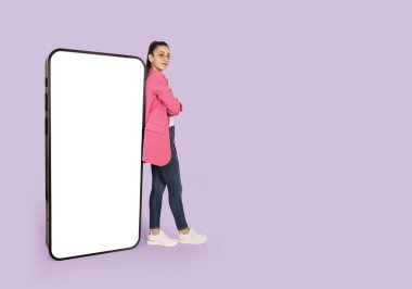 Büyük boş ekran cep telefonu, geniş beden görüşlü iş kadını boş ekran cep telefonuna yaslanmış duruyor. Akıllı telefon maketi. Boşluk alanını izole edilmiş mor arkaplan kopyala. 