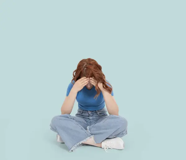 Unhappy woman, unrecognizable caucasian young unhappy woman. Sit floor hold her forehead with two hands. Looking down. Sit floor. Break up problems. Worried, depressed, anxious girl thinking.