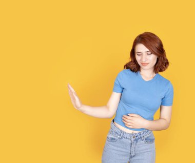 - Benden uzak dur! Avuç içlerine uzanan dur işaretini ifade eden kızıl Bob saçlı Avrupalı beyaz kadın portresi. Yüz ifadesinden hoşlanmadım. Sarı stüdyo arkaplanı, kopyalama alanı.