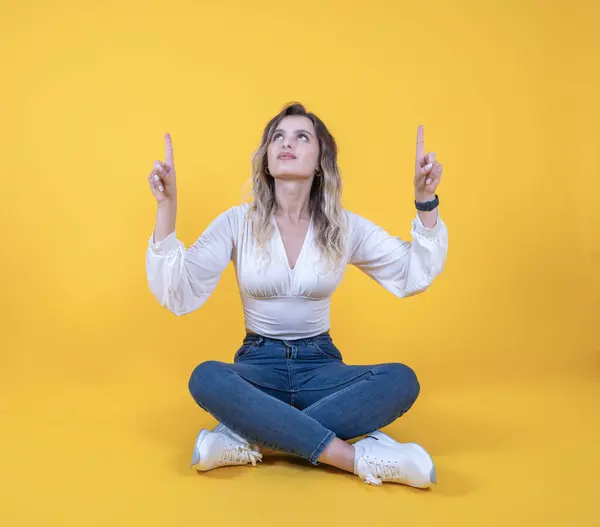 Looking pointing fingers up, full body size photo of charming caucasian woman looking pointing fingers up. Mock up, copy space. Useful tips, banner, advertisement concept idea. Yellow background.