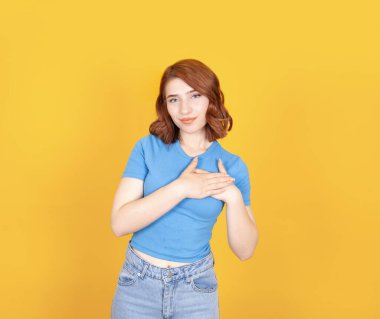 Dokunaklı kalp, güzel kırmızı kısa saçların portresi güzel bir kadının kalbe dokunuşu. El ele tutuşun. Çekici, güzel bir kadın minnettar hissediyor. Avuçlarını göğsüne bastırıyor. Yürek ısıtan, kendinden emin kız..