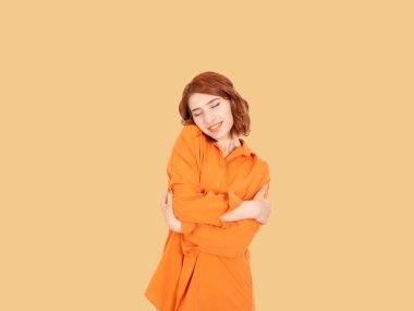 Kendini kucaklayan, sevgi dolu beyaz bir genç kadının kendini kucaklaması. Sevimli hissediyorum, gülümsüyorum, sarılıyorum. Tıpkı senin gibi, sakin, mutlu, pozitif ve kendinden emin kal. Kişisel bakım kavramı fikri görüntüsü.