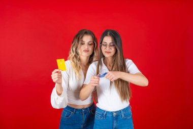 Kırık kredi kartını yok et, beyaz tenli iki çekici en iyi arkadaş kadınların kredi kartını yok etmeye çalışmasını engelle. Hüsrana uğramış kadın tüketici dijital online konsept fikri yüzünden aşırı para harcıyor..