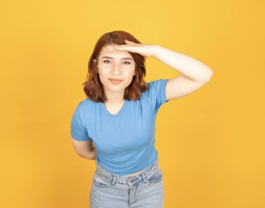 Uzaklara bakan, 20 'li yaşlarda, sarı arka planda el ele tutuşmuş, beyaz tenli, çekici bir kadının portresi. Bir şey ya da birinin fikir görüntüsü aranıyor.