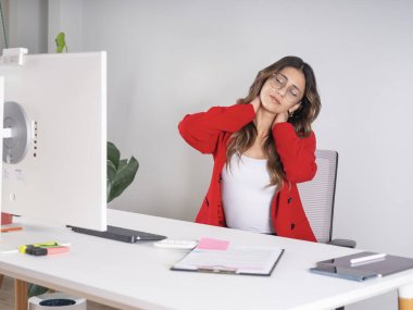 Boyun ağrısından muzdarip, beyaz tenli iş kadını boyun ağrısından muzdarip, sert kaslarına masaj yapıyor. Ofiste masa başında oturuyor. Aşırı çalışma stres kavramı fikir görüntüsü.