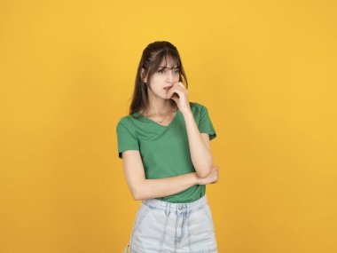 Endişeli üzgün kadın, 20 'li yaşlarda beyaz tenli çekici esmer kadın portresi sarı arka planda izole edilmiş üzgün kadın mesafeye bak mutsuz hisset, bazı sorunlar yaşadığını düşün..