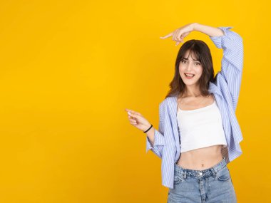 Kadın işaret parmağı bir yana, genç beyaz 20 'li yaşların portresi güzel seksi kadın işaret parmakları bir yana sarı stüdyo arka planında izole edilmiş metin alanı. Yaşam tarzı tanıtım fikri.